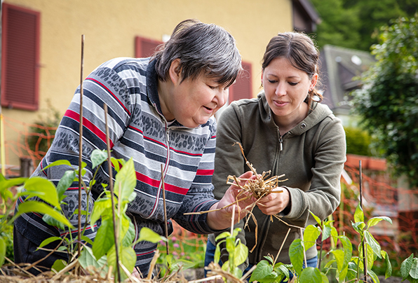 Woman with disability and carer gardening together