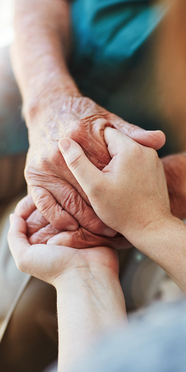 Closeup of senior and young person holding hands