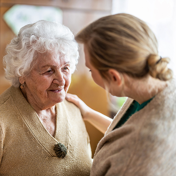 Young female carer with hand on shoulder of senior woman