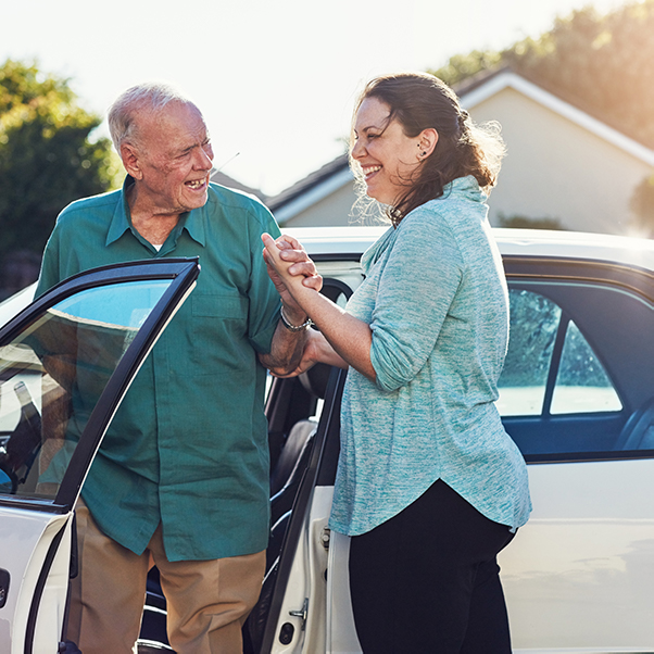 A senior woman and a young caregiver are engaged in a puzzle activity, smiling as they hold colorful puzzle pieces. This scene illustrates the importance of social interactions in elderly care.