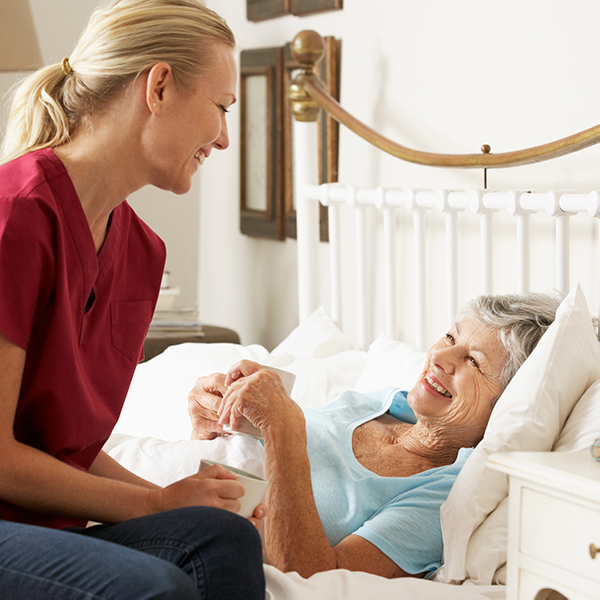 A healthcare professional gently holds the hands of a patient receiving treatment, symbolizing compassion and care in a medical environment.